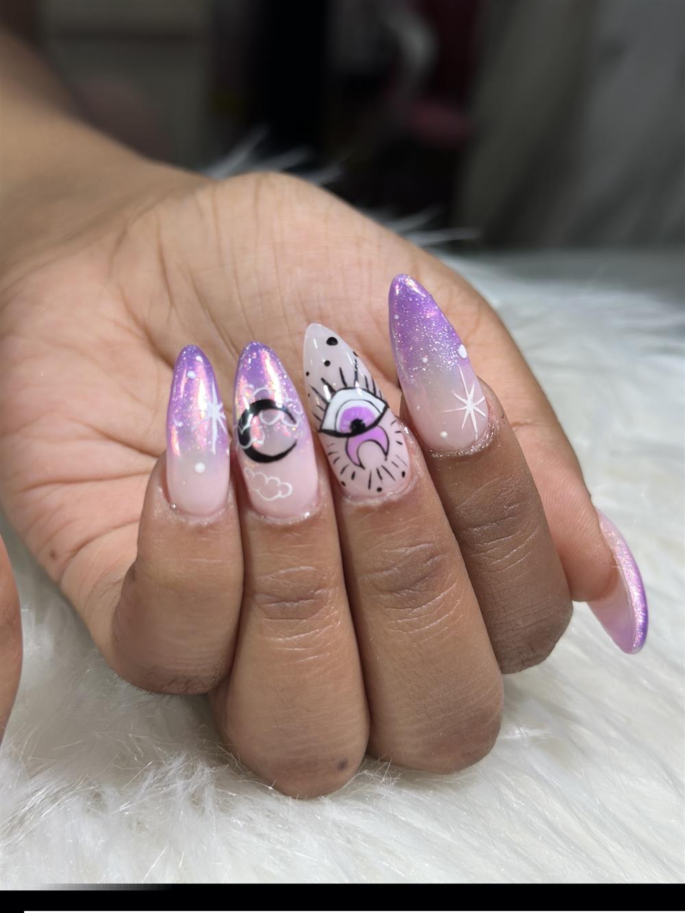 Uñas largas lilas con ojo turco y destellos